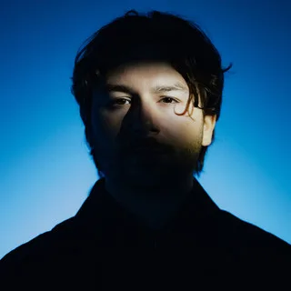 Marcus Santoro lit from the side against a blue background