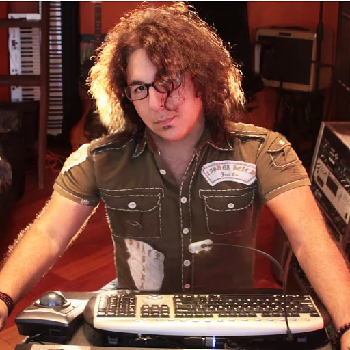 Reuven Amiel at his studio desk behind a keyboard and a trackball