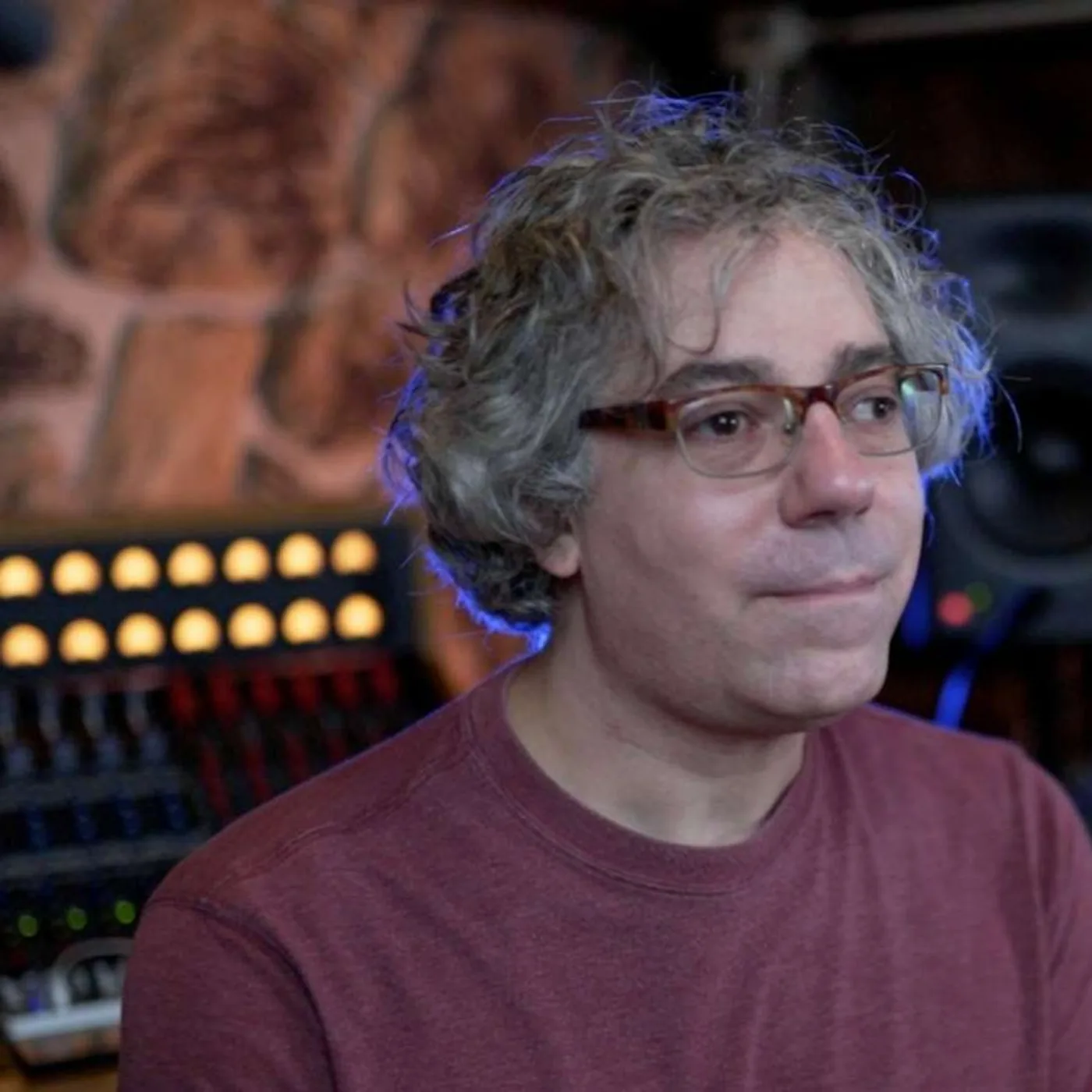 Steve DeMott in his studio, with a console and a monitor speaker behind him